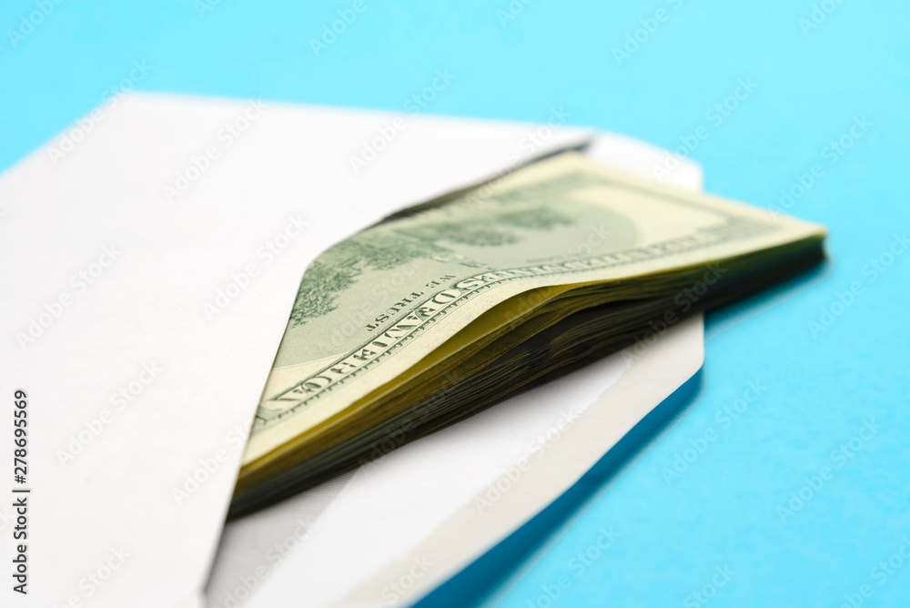 American dollars in open white postal envelope on a blue background American dollars in open white postal envelope on a blue background