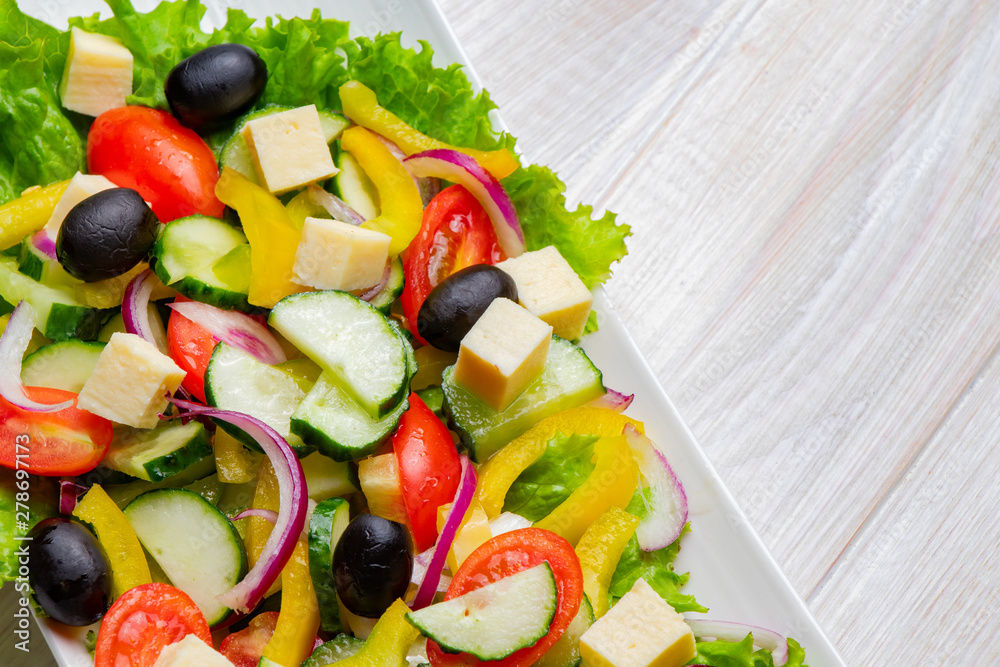 Light summer vegetable salad on a white plate. Close-up, top view