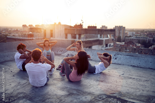 Group of happy fit friends exercising outdoor in city