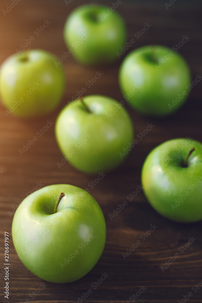 Group of green apples on brown wooden background. Close up