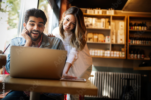 Portrait of a cheerful couple shopping online with laptop