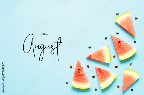 Inscription Hello August. Fresh red watermelon slice Isolated light blue background. Top view, Flat lay. - Image