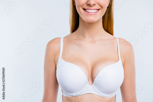 Cropped close-up portrait of nice confident attractive lovely cheerful cheery blonde girl chest after uplift injection wearing bra isolated over light gray background photo