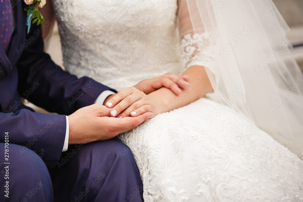 Wedding couple in love, bride and groom holding hands at wedding day Wedding couple in love, bride and groom holding hands at wedding day
