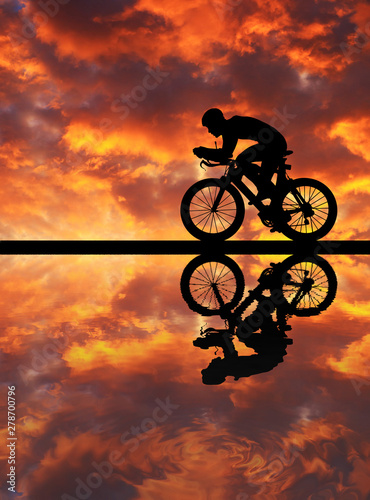 Silhouette  Cycling  on blurry sunrise  sky   background. © rathchapon