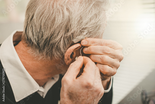 Photos Man putting hearing aids