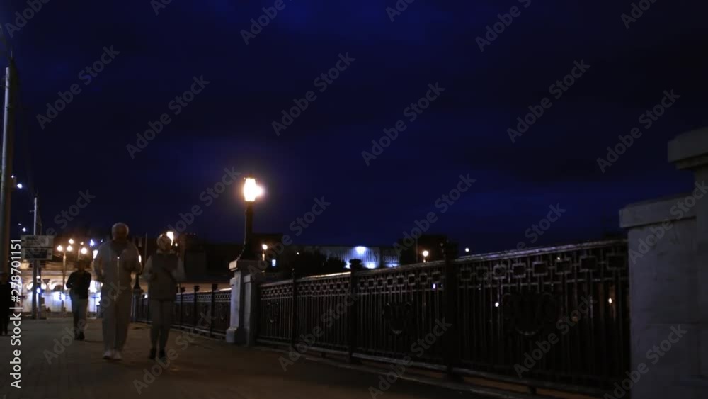 Happy active senior people jogging along embankment outdoors in evening Happy active senior people jogging along embankment outdoors in evening