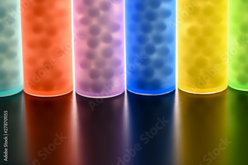 Modern Color homeopathic pills in plastic container on black background photo