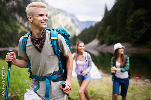 Group of happy friends with backpacks hiking together