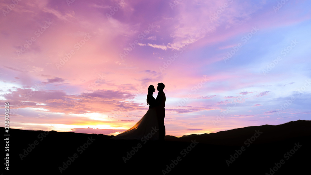 Silhouette of young married couple at sunset.Valentine's day concept.	
