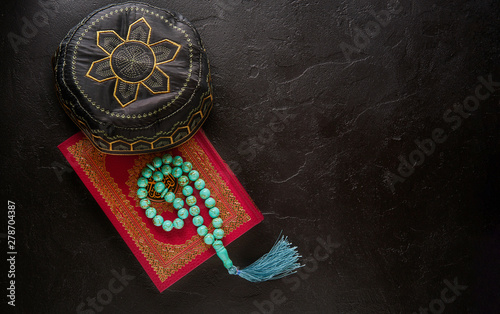 Islamic concept. Flat lay composition of holy book for muslim Quran, rosary beads and pray hat. © GoSlow