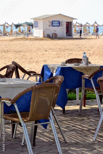 Outdoor restaurant tables near the San Pierto beach, Albania. photo