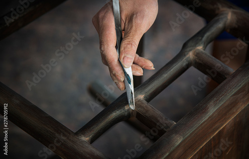Workers grind furniture with abrasive cloth