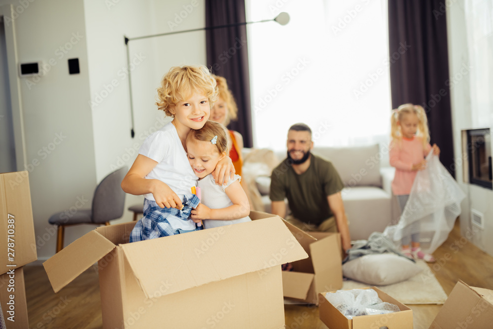Positive blonde boy hugging his younger sister Positive blonde boy hugging his younger sister