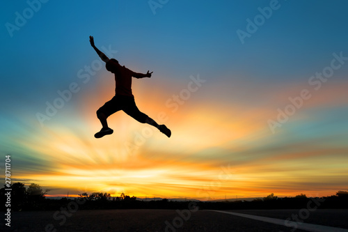Happy man jumping At the time of the sun set Concept of vacation and travel