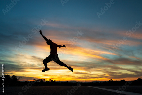 Happy man jumping At the time of the sun set Concept of vacation and travel