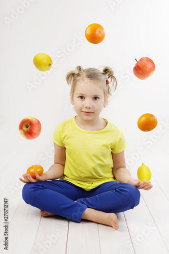 Little 5 years old girl juggling fruits, concept of healthy eating, vitamins for kids