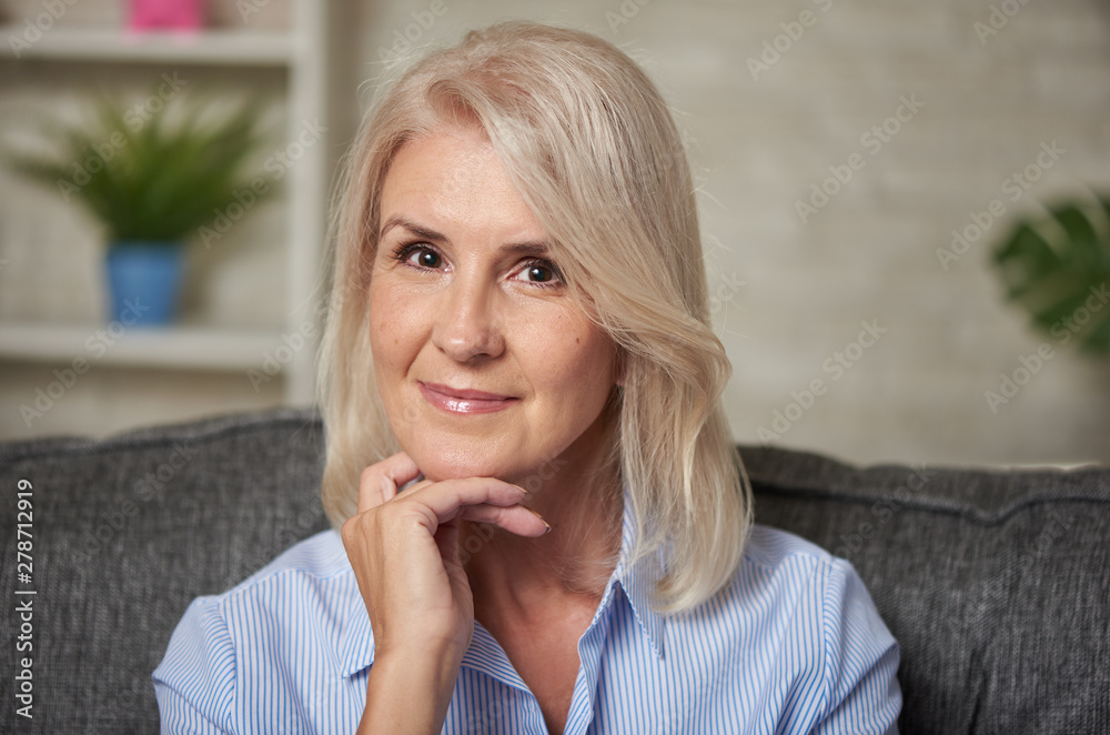 Beautiful 50 years old woman relaxing on sofa at home Beautiful 50 years old woman relaxing on sofa at home
