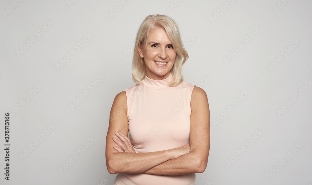 Beautiful 50 years lady with hands folded is smiling. Isolated Beautiful 50 years lady with hands folded is smiling. Isolated