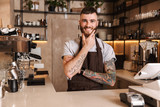 Smiling attractive man barista standing