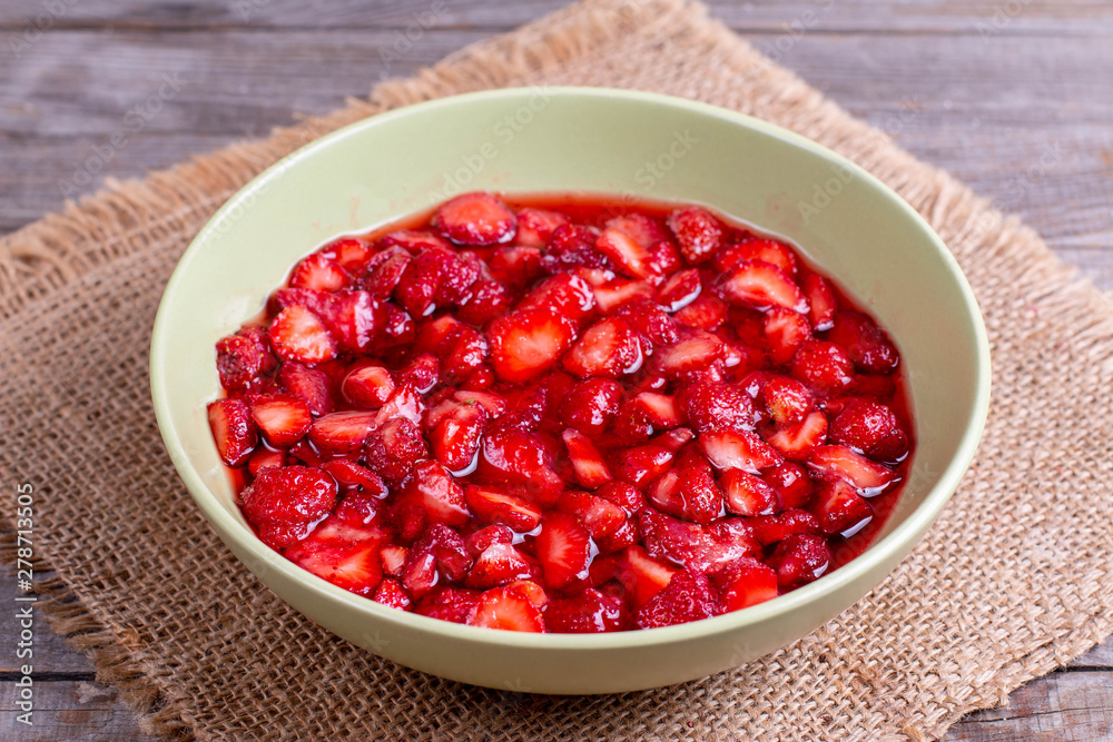 Slices of strawberries with sugar in a bowl Slices of strawberries with sugar in a bowl
