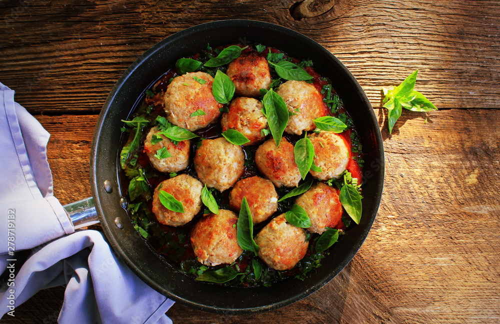 Meatballs in sweet and sour tomato sauce on rustic table. Top view