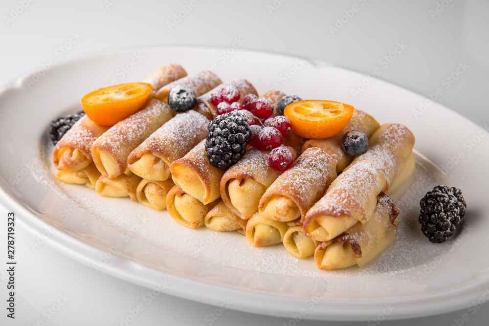 Dessert. Sweet pancakes with jam, caramel, fruit and berries. Banquet festive dishes. Fine dining restaurant menu. White background. Dessert. Sweet pancakes with jam, caramel, fruit and berries. Banquet festive dishes. Fine dining restaurant menu. White background.