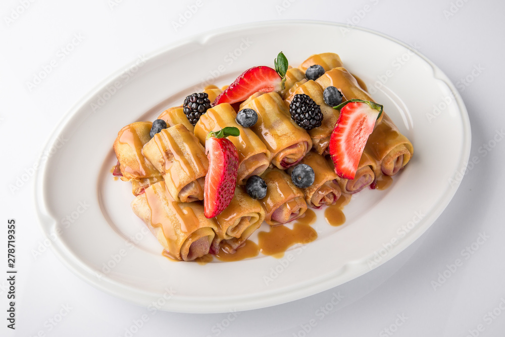 Dessert. Sweet pancakes with jam, caramel, fruit and berries. Banquet festive dishes. Fine dining restaurant menu. White background. 