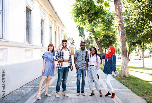 Multiracial young friends posing at the street and having fun.