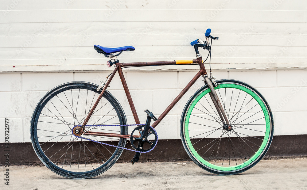 Old fixed gear bicycle on white wall background