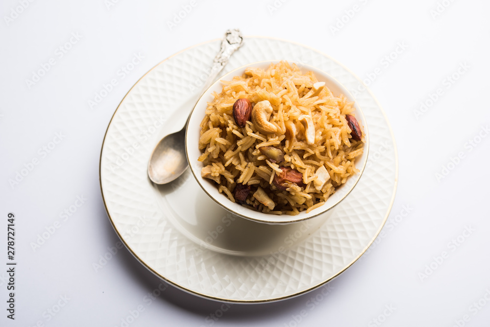 Traditional Jaggery Rice or Gur wale chawal in Hindi, served in a bowl with spoon. selective focus Traditional Jaggery Rice or Gur wale chawal in Hindi, served in a bowl with spoon. selective focus