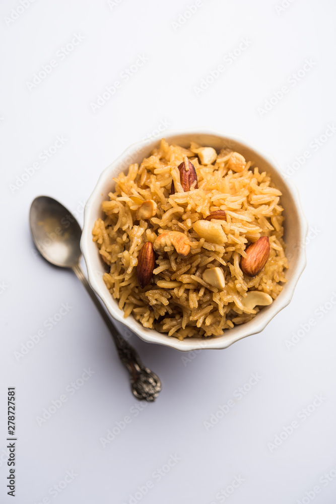 Traditional Jaggery Rice or Gur wale chawal in Hindi, served in a bowl with spoon. selective focus Traditional Jaggery Rice or Gur wale chawal in Hindi, served in a bowl with spoon. selective focus