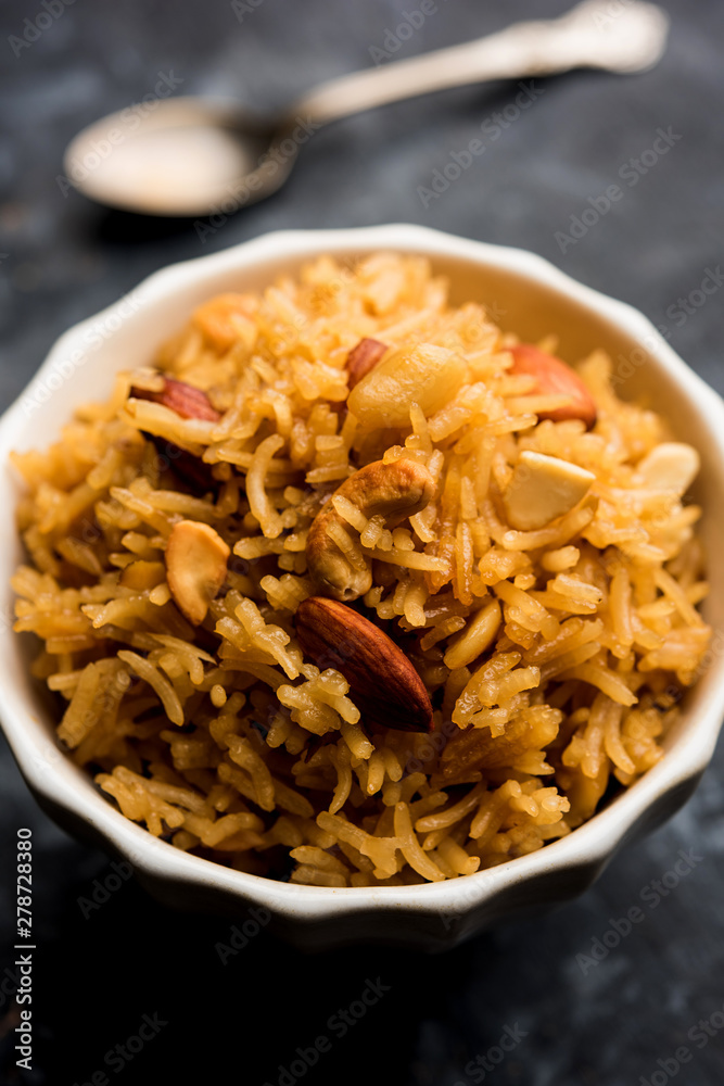 Traditional Jaggery Rice or Gur wale chawal in Hindi, served in a bowl with spoon. selective focus Traditional Jaggery Rice or Gur wale chawal in Hindi, served in a bowl with spoon. selective focus