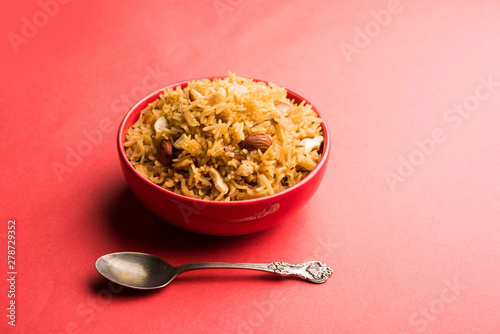 Traditional Jaggery Rice or Gur wale chawal in Hindi, served in a bowl with spoon. selective focus photo