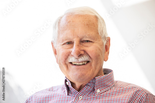 portrait of senior, old men smile and is relaxed in his garden with a white wand