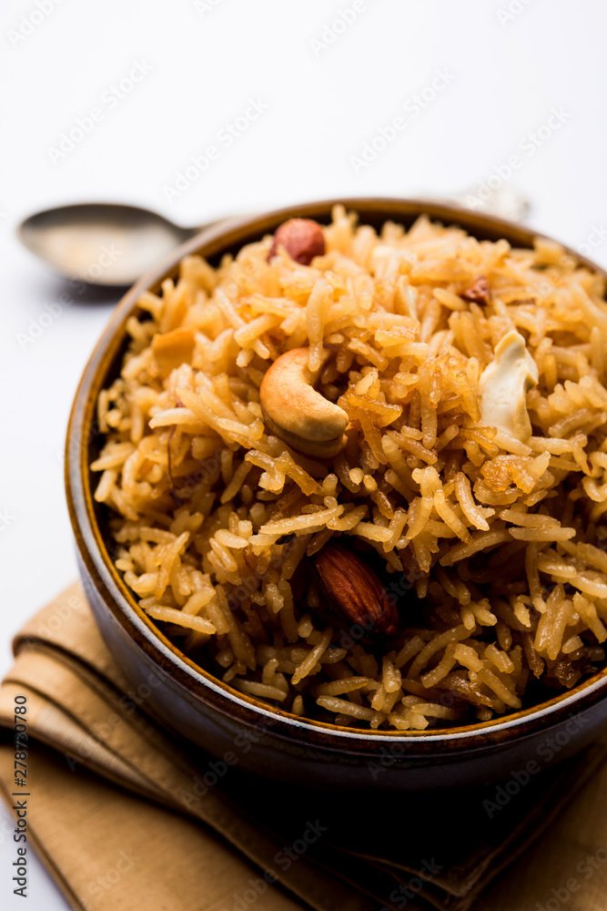 Traditional Jaggery Rice or Gur wale chawal in Hindi, served in a bowl with spoon. selective focus Traditional Jaggery Rice or Gur wale chawal in Hindi, served in a bowl with spoon. selective focus