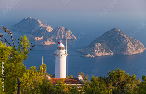 White lighthouse against blue sea background