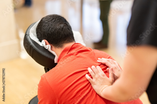 Man receiving shiatsu on a quick massage chair photo