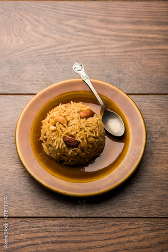 Traditional Jaggery Rice or Gur wale chawal in Hindi, served in a bowl with spoon. selective focus