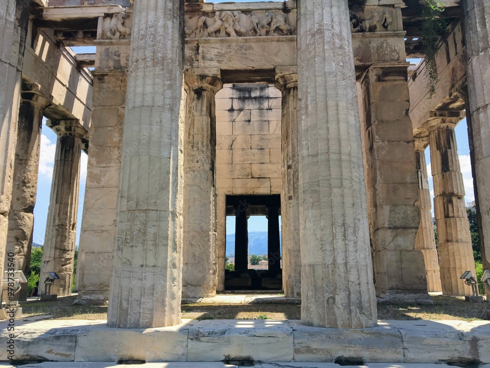 A unique view looking through the columns of the doric columns of The Temple of Hephaestus or Hephaisteion or earlier as the Theseion, which is a well-preserved Greek temple in Athens, Greece