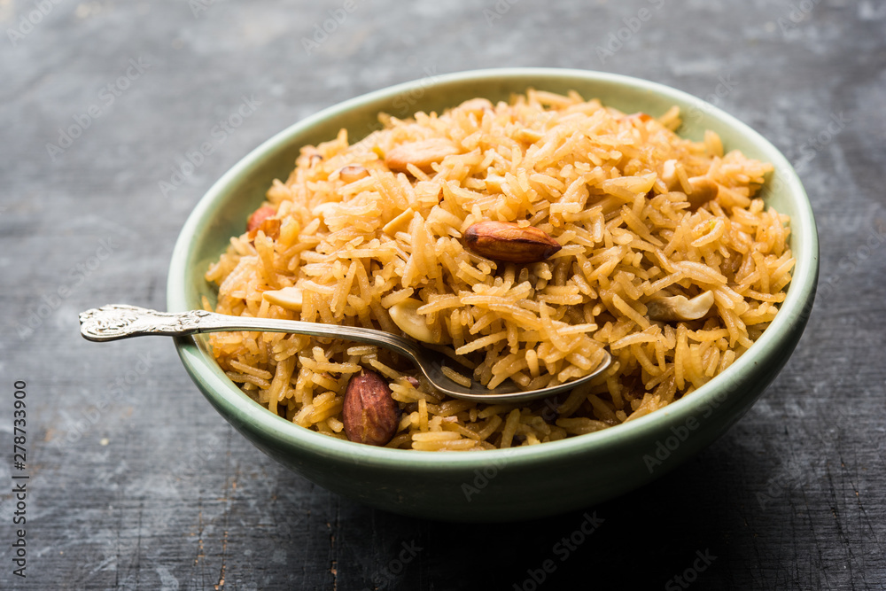 Traditional Jaggery Rice or Gur wale chawal in Hindi, served in a bowl with spoon. selective focus Traditional Jaggery Rice or Gur wale chawal in Hindi, served in a bowl with spoon. selective focus