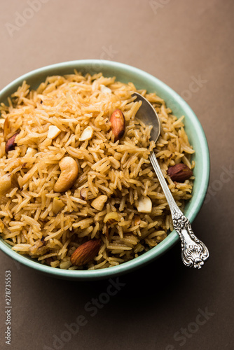 Traditional Jaggery Rice or Gur wale chawal in Hindi, served in a bowl with spoon. selective focus photo