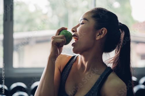 Attractive smiling young asian woman holding  green apple to eat. Healthy concept.