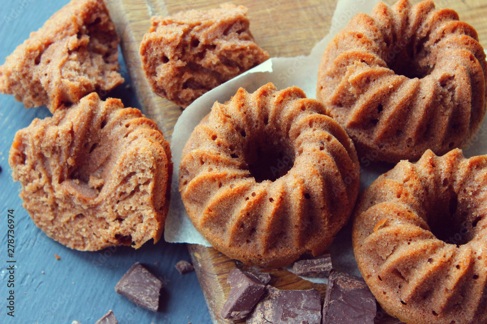Muffins sprinkled with powdered sugar on a wooden background. Homemade cake. Sweet home-made dessert. Copy space. Muffins sprinkled with powdered sugar on a wooden background. Homemade cake. Sweet home-made dessert. Copy space.