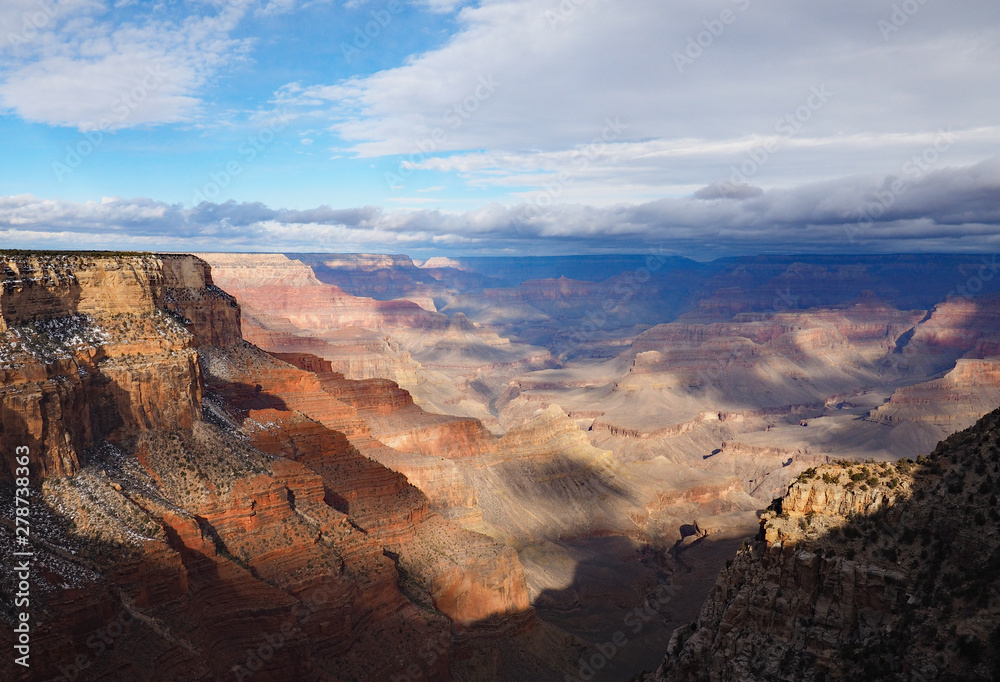 View of the Grand Canyon under a complex cloudscape from the South Rim Trail in Grand Canyon National Park, Arizona, in winter.