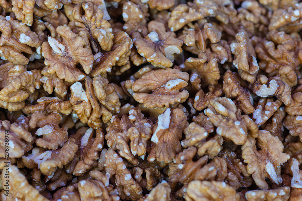 Fresh walnut seeds in a pile on display for sale. Healthy organic natural food. Brown color background or pattern