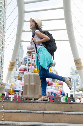 Tourist With Luggage Standing On Footpath In City During Christmas