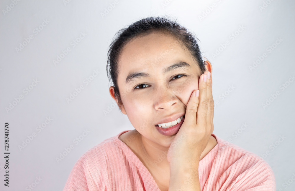 Asian woman touching cheek with hand because she is suffering of toothache. Dental care and health concept. Asian woman touching cheek with hand because she is suffering of toothache. Dental care and health concept.