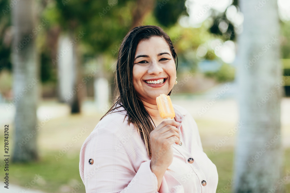 Portrait of woman eating popsicle in the park Portrait of woman eating popsicle in the park