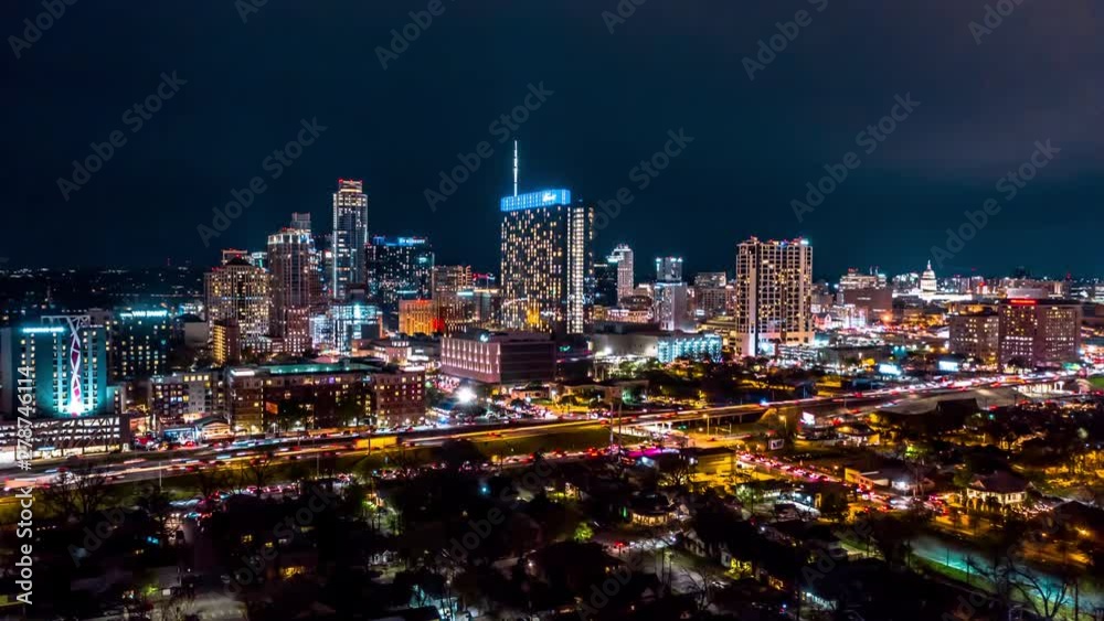 Nighttime hyperlapse of Austin skyline. Drone circles to the right as traffic and skyscrapers light up the city.